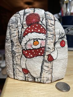 a rock with a snowman painted on it