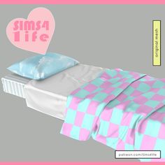 a bed with two pillows on top of it next to a pink and blue blanket