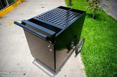 a black grill sitting on top of a sidewalk next to a green grass covered field