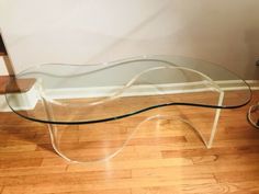 a glass table sitting on top of a hard wood floor