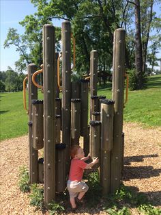 a small child playing in a wooden structure