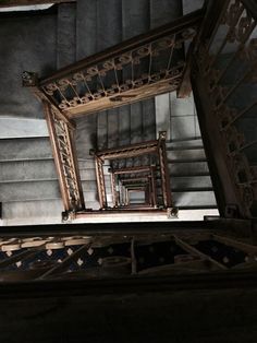 an old wooden staircase with metal railings and handrails in the dark room