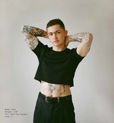 a young man with tattoos on his arms and chest posing for a photo in front of a white background