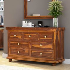 a wooden dresser sitting in front of a mirror