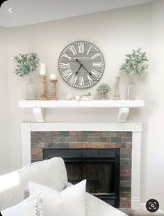 a living room with a fireplace and clock on the wall above it's mantle