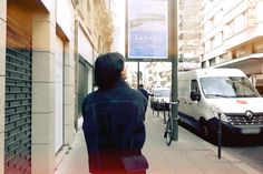 a woman walking down the street in front of a van