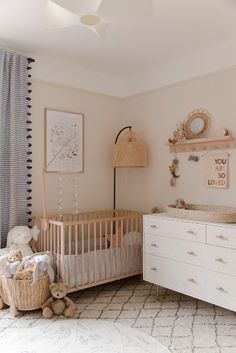 a baby's room with a crib and dresser