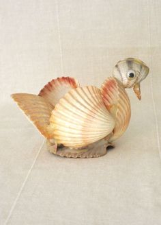 a small sea shell with a fish on it's back end, sitting on a white surface