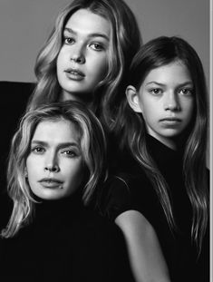 three women are posing for the camera in black and white, with one woman looking at the camera