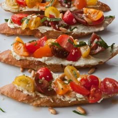 three pieces of bread with tomatoes and other vegetables on them sitting on a white plate