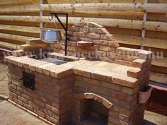 an outdoor brick oven built into the side of a wooden fence