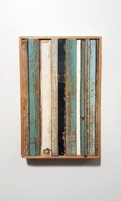 an old wooden box with blue and white paint on it's sides is hanging on the wall