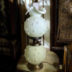 a white lamp sitting on top of a wooden table