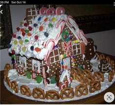 a gingerbread house decorated with candy and pretzels