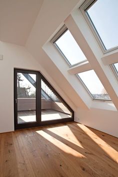 an empty room with wooden floors and skylights on the roof top window sill