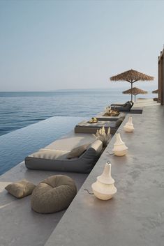 a row of lounge chairs sitting next to an ocean