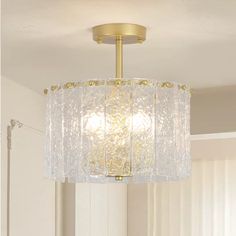 a chandelier hanging from the ceiling in a room with white walls and windows