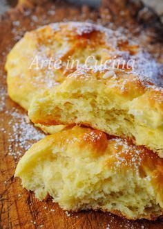 two pieces of bread sitting on top of a wooden cutting board covered in powdered sugar