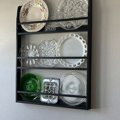 a black shelf with plates and dishes on it