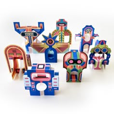 an assortment of brightly colored wooden toys on a white surface