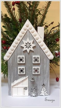 a small wooden house with snowflakes on the roof