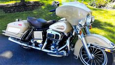 a motorcycle is parked on the side of the road in front of some grass and trees