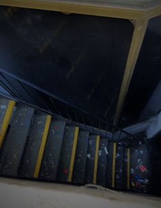 an escalator with yellow and black railings leading up to the top floor