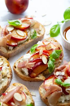 several pieces of bread with toppings on them next to an apple and cup of tea