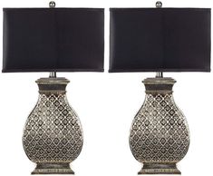 two silver vases with black lamps on them