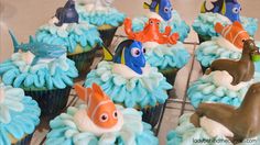 cupcakes decorated with blue frosting and various sea animals on top of them