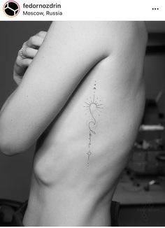 the back of a woman's body with a tattoo on her left arm and shoulder