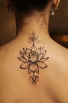 the back of a woman's neck with a lotus tattoo on it