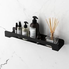 a bathroom shelf with soap, lotion and candles on it