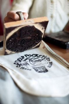 a stamper being used to make a logo for a coffee shop on a table