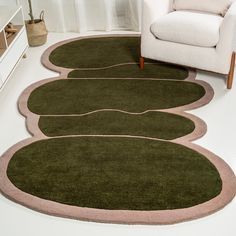 three green rugs on the floor in a living room