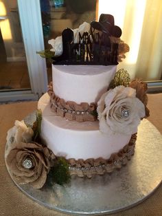 a three tiered cake decorated with flowers and ribbons