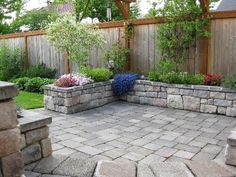 an outdoor patio with stone walls and landscaping