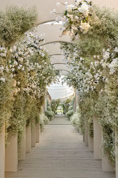 the walkway is lined with white flowers and greenery