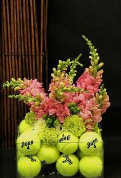 a vase filled with tennis balls and flowers