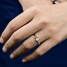 a close up of a person wearing a ring on their finger with a diamond in the middle