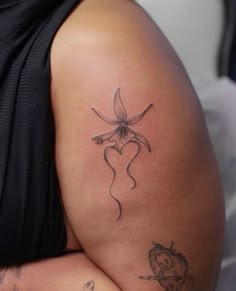 a woman's arm with a tattoo on it and a flower in the shape of a heart