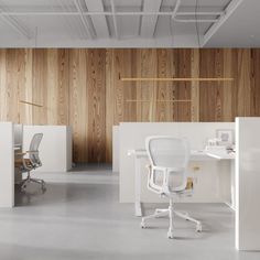 an office with wooden walls and white desks in the foreground, along with two chairs on either side