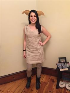 a woman standing in front of a wall with an animal head on it's head