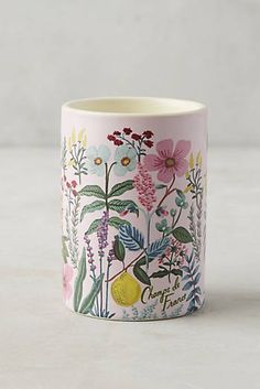 a cup with flowers and fruit on it