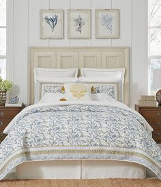 a bed with white and blue comforters in a bedroom