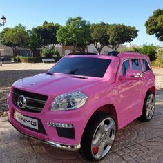 a pink mercedes benz suv parked in front of a house