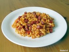 a white plate topped with macaroni and cheese on top of a wooden table