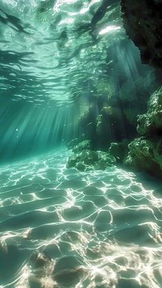 the sun shines through the water as it passes over rocks and under the ocean floor