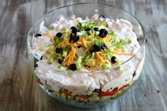 a glass bowl filled with food on top of a wooden table