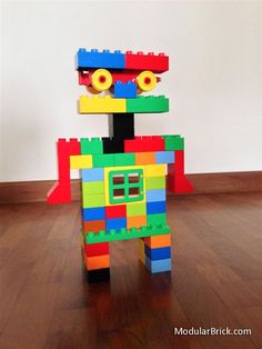 a toy made out of legos sitting on top of a hard wood floor next to a wall